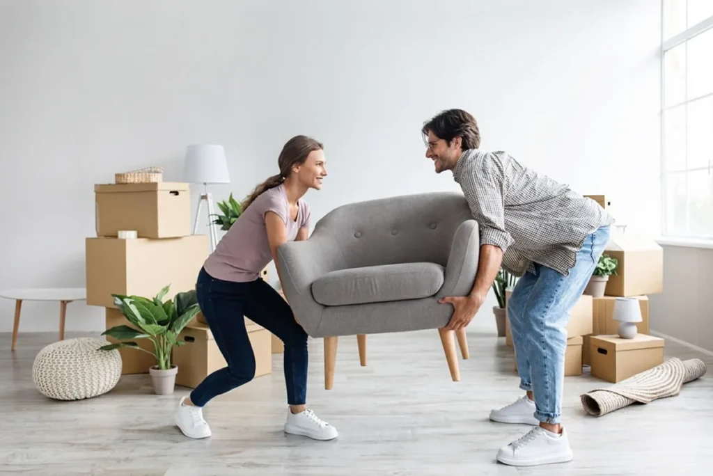Couple carefully carrying a sofa through a doorway during a home relocation in Melbourne