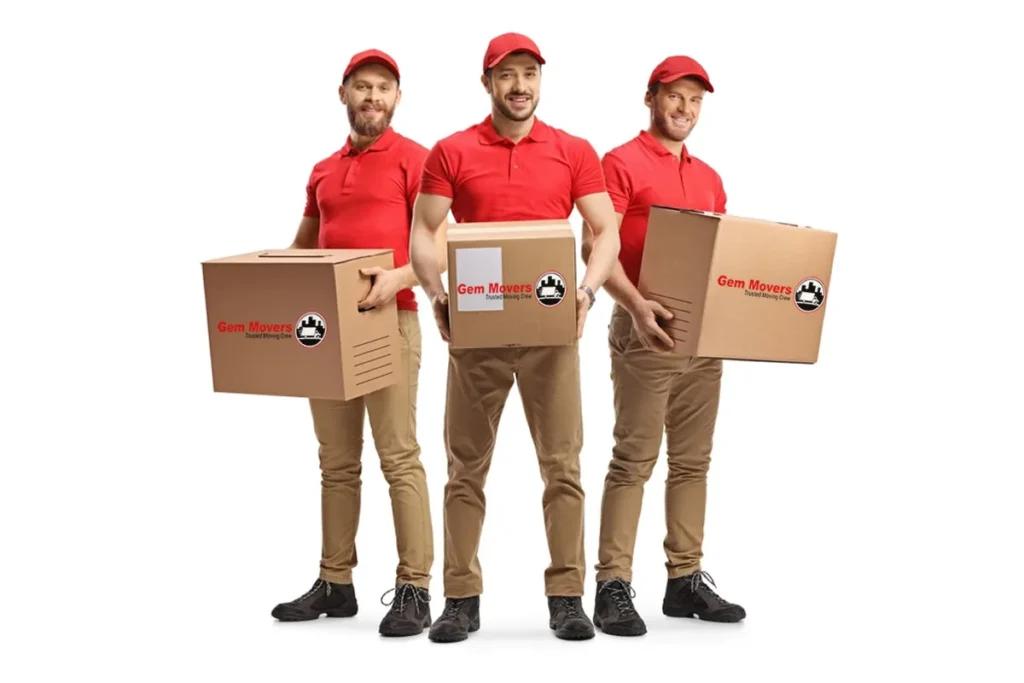 Three professional removalists in Melbourne carefully carrying packed moving boxes during a house move
