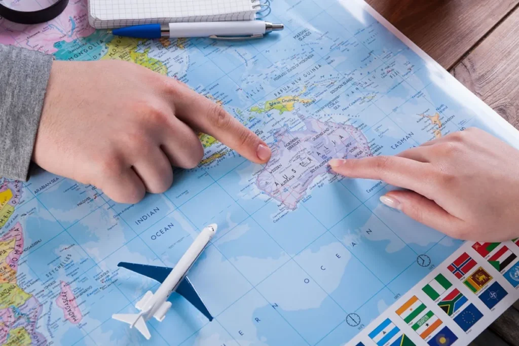 Two people pointing at locations on an Australian map while planning an interstate relocation in 2026