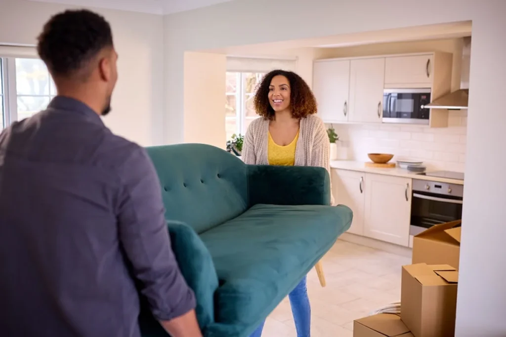 Couple carrying sofa while preparing for a house move in Melbourne