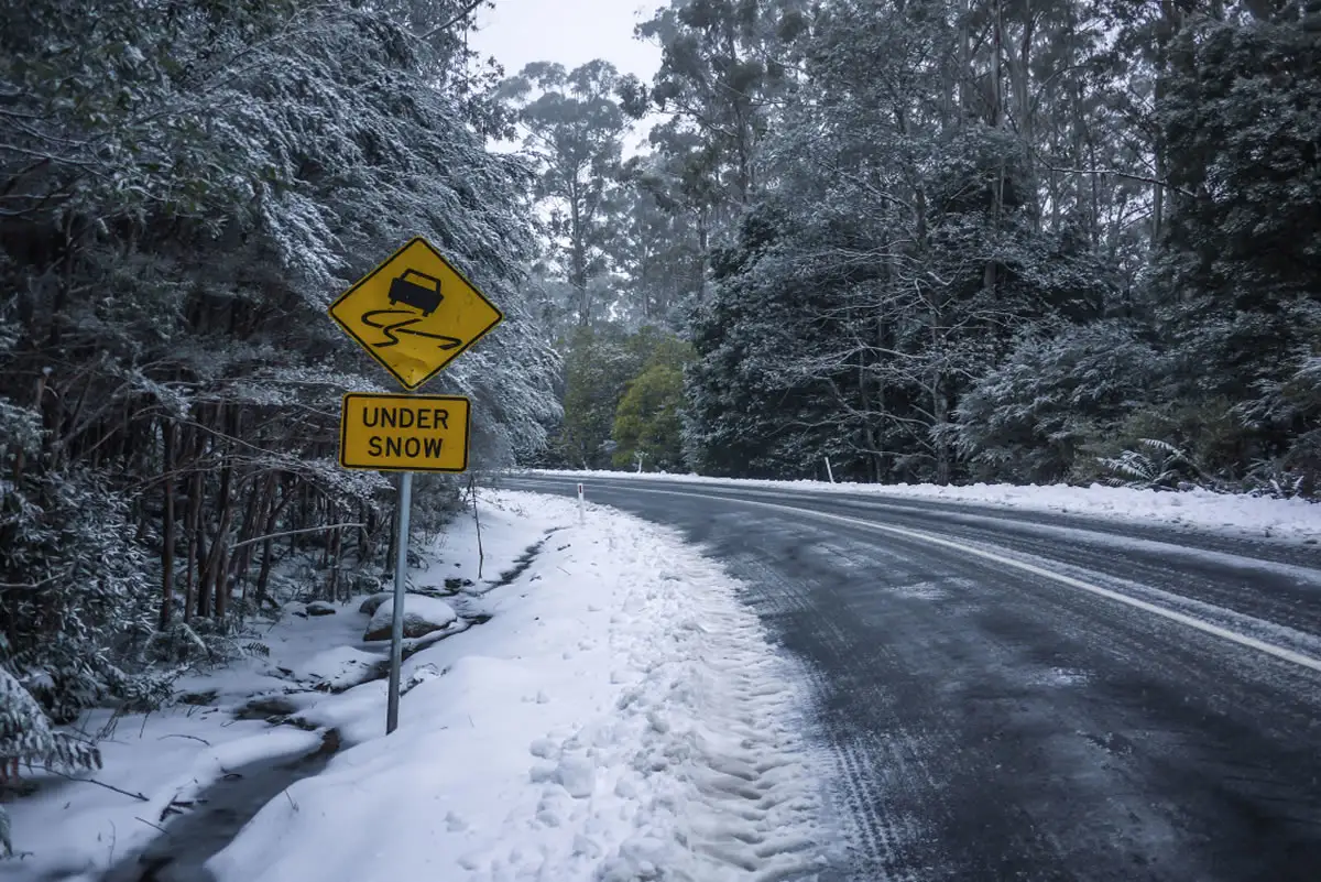 A Melbourne, Australia road in winter with snow visible along the roadsides